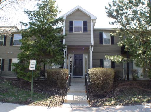 Front view of a two-story residential building with an entrance pathway.