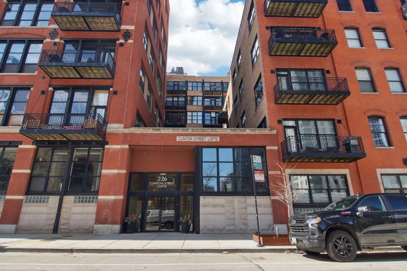 Front view of a multi-story brick building with multiple balconies.