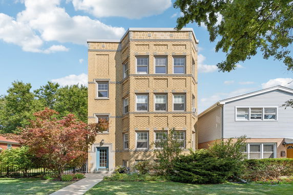 Front view of a three-story brick building with multiple windows.