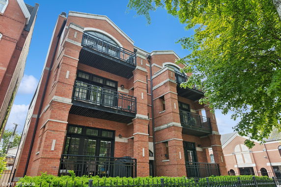 Front view of a multi-story brick building with balconies.
