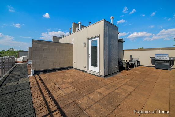 Rooftop area with patio seating and a grill.
