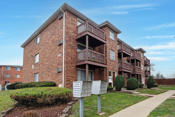 Front view of a three-story apartment building with balconies.