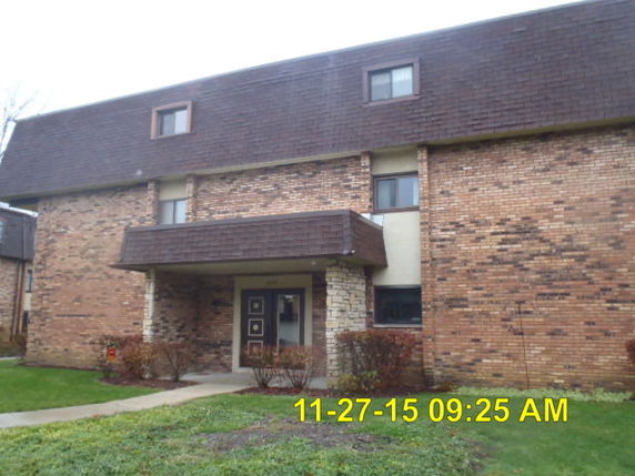 Front view of a multi-story brick building with a small entrance.