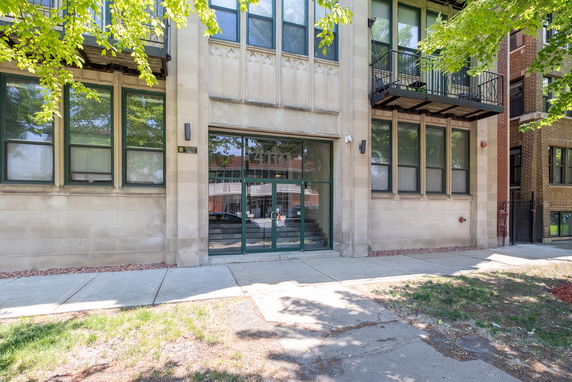 Front view of a building with large windows and a central glass entry door.