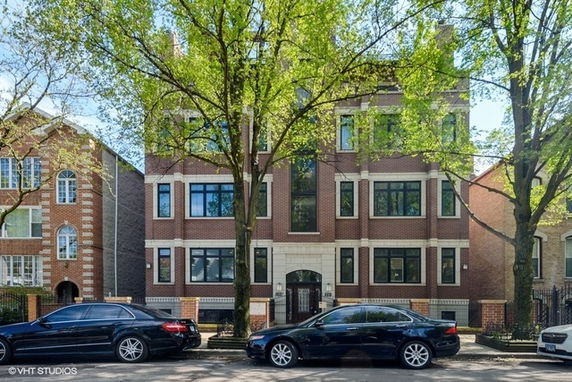 Front view of a multi-story brick building with large windows.