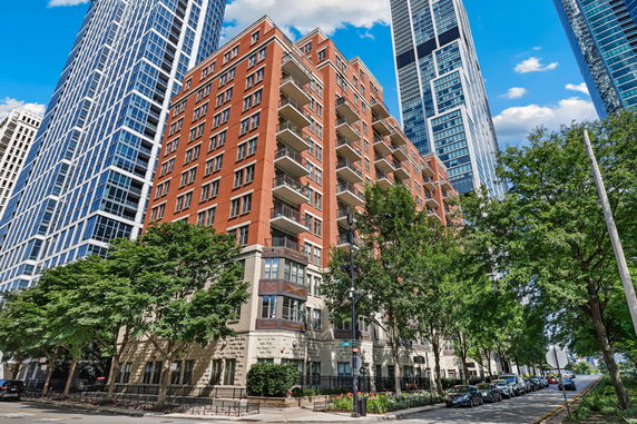 Street-level view of a multi-story brick apartment building with balconies.