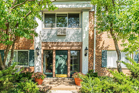 Front view of a house with a brick facade and green door.