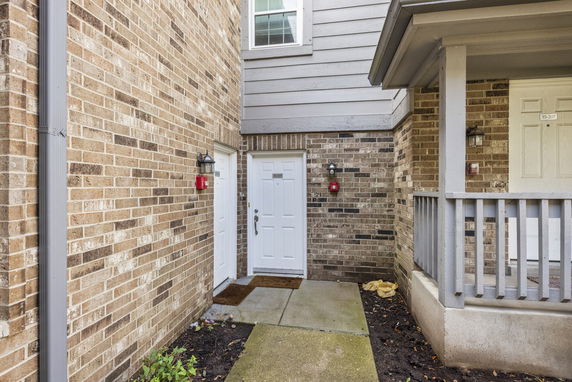 Close-up view of the entrance to a brick townhouse with white doors.