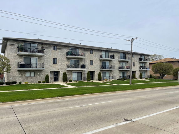 Front view of a three-story apartment building with balconies.