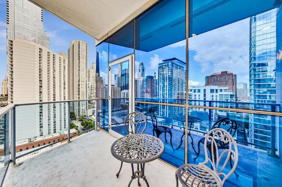 Balcony with cityscape view featuring multiple skyscrapers.