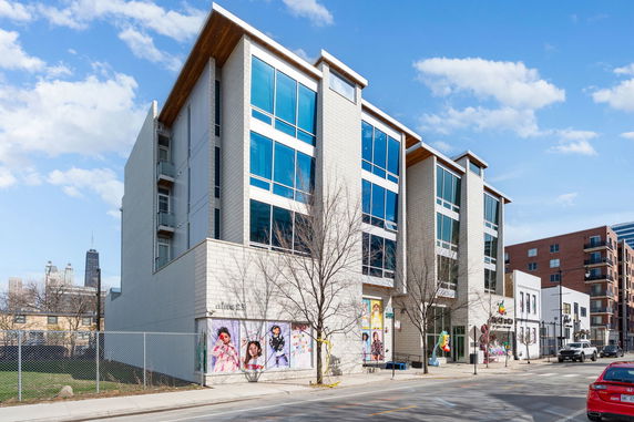 Front view of a modern multi-story building with large windows.