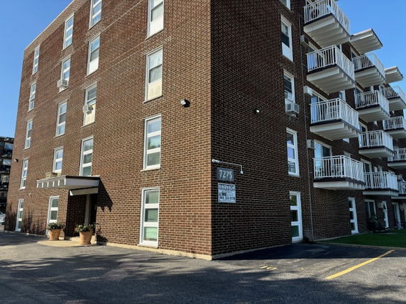 Front view of a multi-story brick building with balconies.