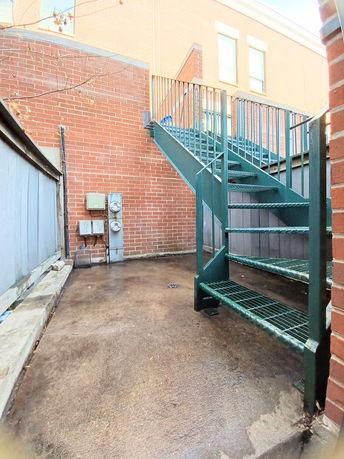 Outdoor view of a building with a staircase leading to the upper level.