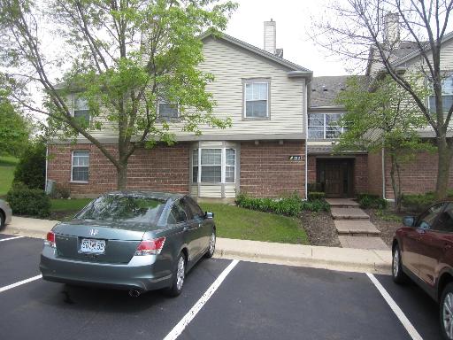 Front view of a two-story townhouse with brick and siding exterior.