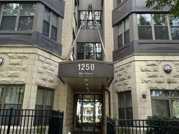 Front entrance of a multi-story building with brick and stone exterior.