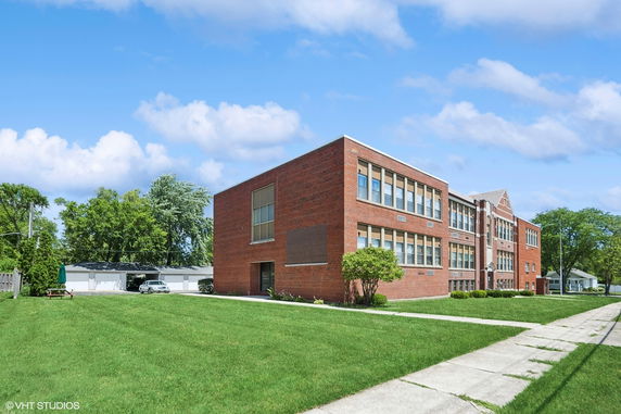 Front view of a large multi-story brick building with numerous windows.