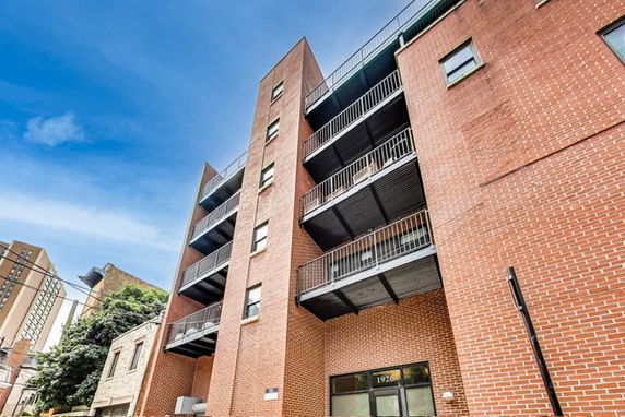 Front view of a multi-story brick building with balconies.