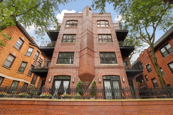 Front view of a multi-story brick building with balconies.