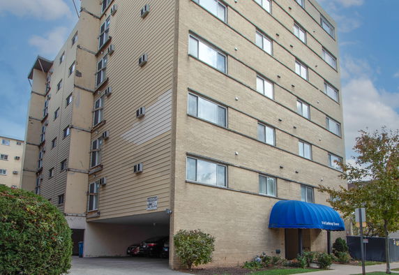 Front view of a multi-story apartment building with parking area beneath.