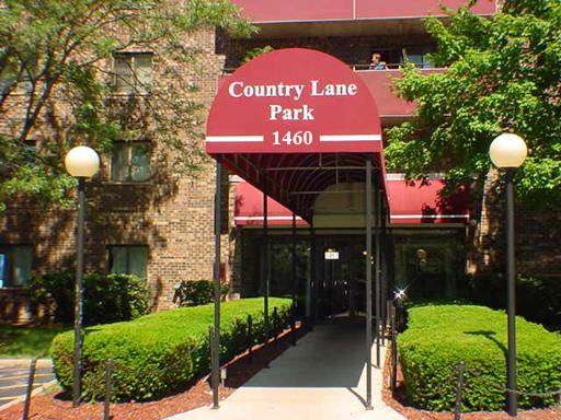 Front view of a multi-story building with a red awning labeled 'Country Lane Park 1460'.