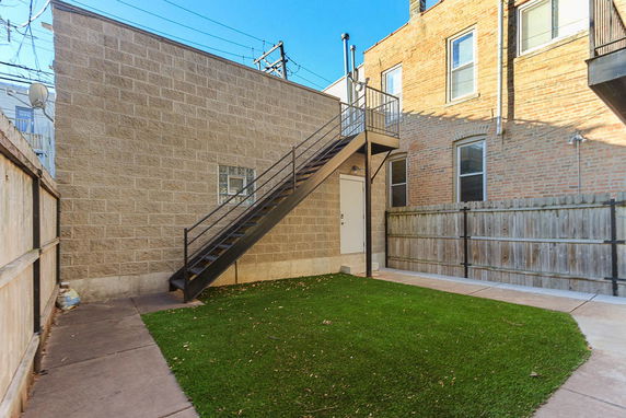 View of a building with an exterior staircase leading to a second story entrance.
