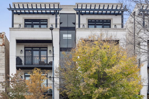 Front view of a multi-story building with brick facade and balconies.