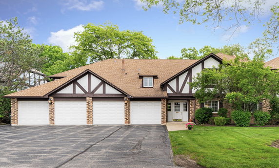 Front view of a house with a four-car garage and brown roof.