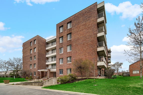 Exterior view of a multi-story brick apartment building with balconies.