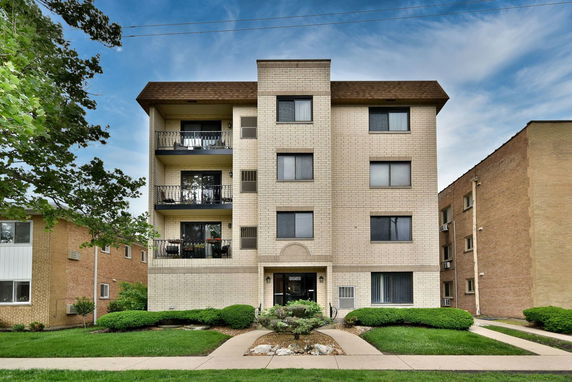 Front view of a four-story apartment building with balconies.
