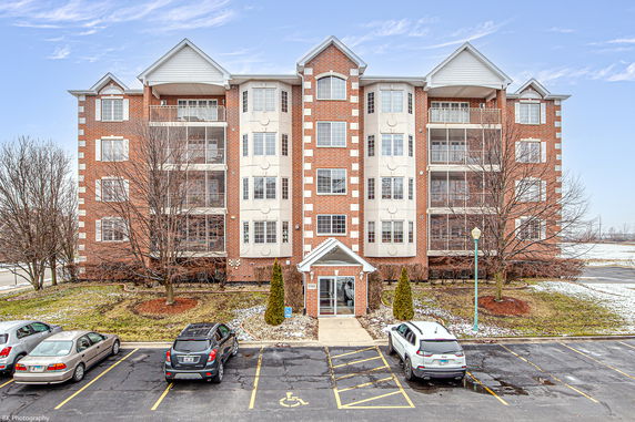 Front view of a multi-story apartment building with brick facade.