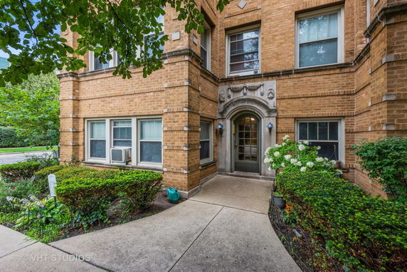 Front view of a brick apartment building with a decorative entrance.