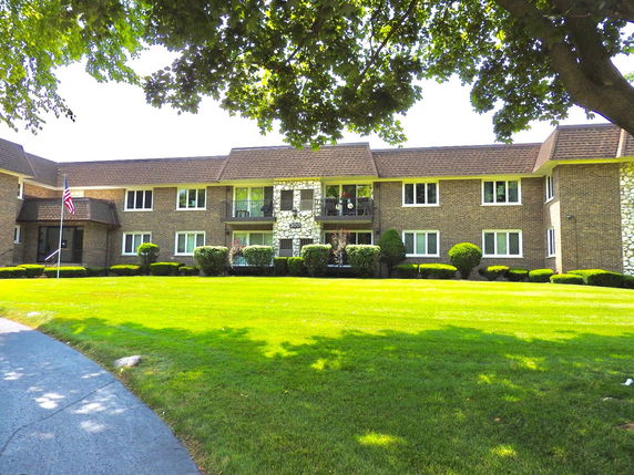Front view of a two-story brick apartment building with a central entrance.