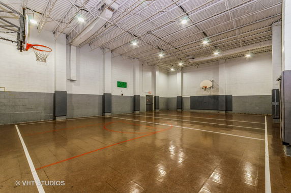 Indoor basketball court with a high ceiling and two basketball hoops.