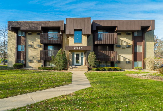Front view of a multi-story apartment building with balconies.