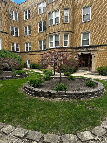 Front view of a multi-story brick apartment building with multiple windows.