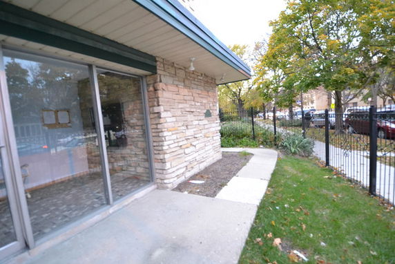 Front view of a building with stone exterior and large glass doors.