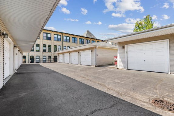 Outdoor parking area with multiple garages attached to a building.