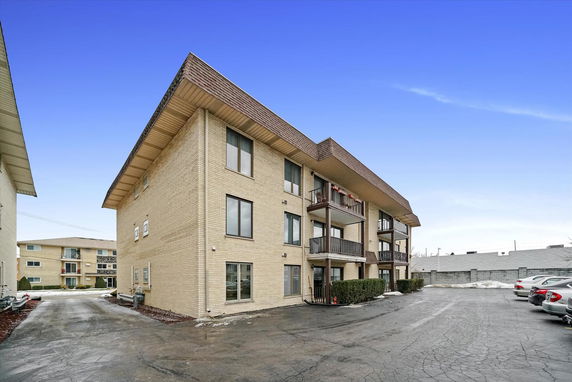 Front view of a multi-story apartment building with balconies.