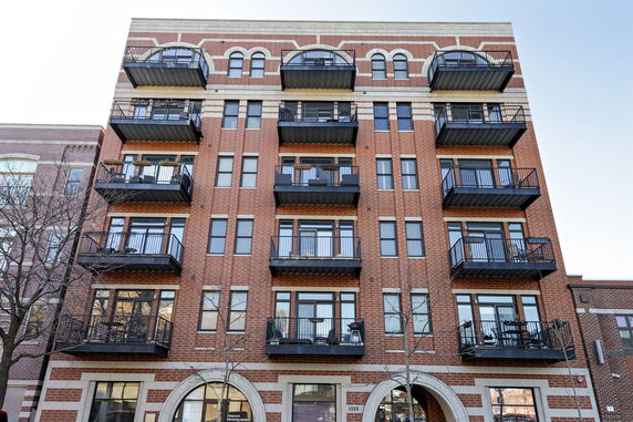 Front view of a multi-story brick building with balconies.