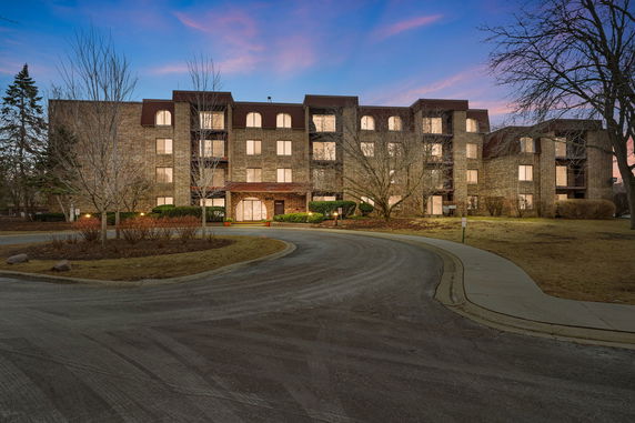 Front view of a multi-story brick building with a circular driveway.