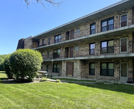 Front view of a three-story apartment building with balconies.