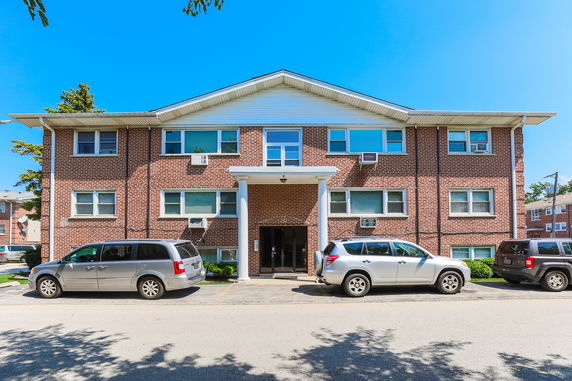Front view of a two-story brick building with several windows and a central entrance.