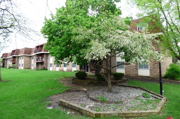 Front view of a multi-story brick apartment building with balconies.