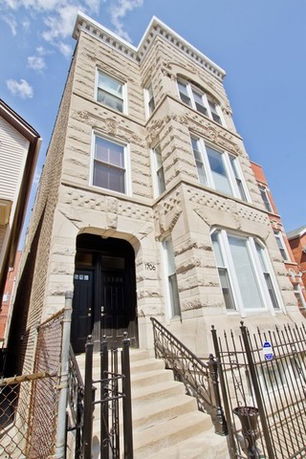 Front view of a multi-story residential building with ornate stonework.