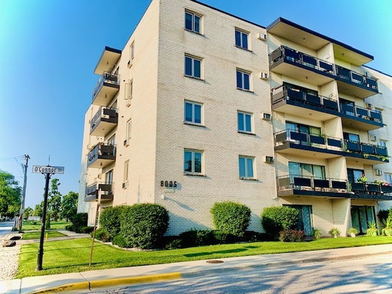 Front view of a multi-story residential building with balconies.