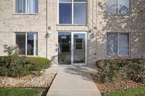 Front view of a building with a brick façade and glass entrance door.