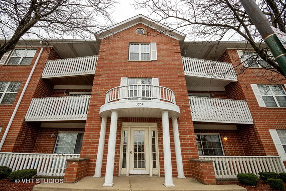 Front view of a multi-story brick building with white balconies and columns.