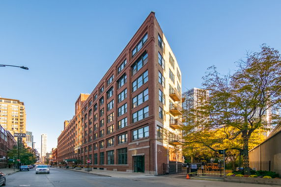 Front view of a multi-story brick building with numerous windows and balconies.