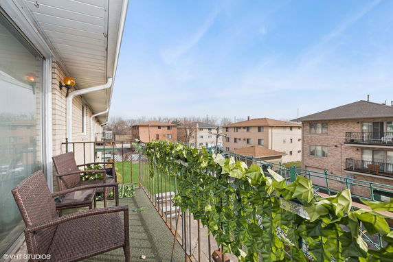View from a balcony with chairs, overlooking neighboring buildings.