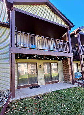 Front view of a two-story house with a balcony and decorative lights.